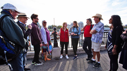 Group of people standing on a bridge with a cityscape in the background