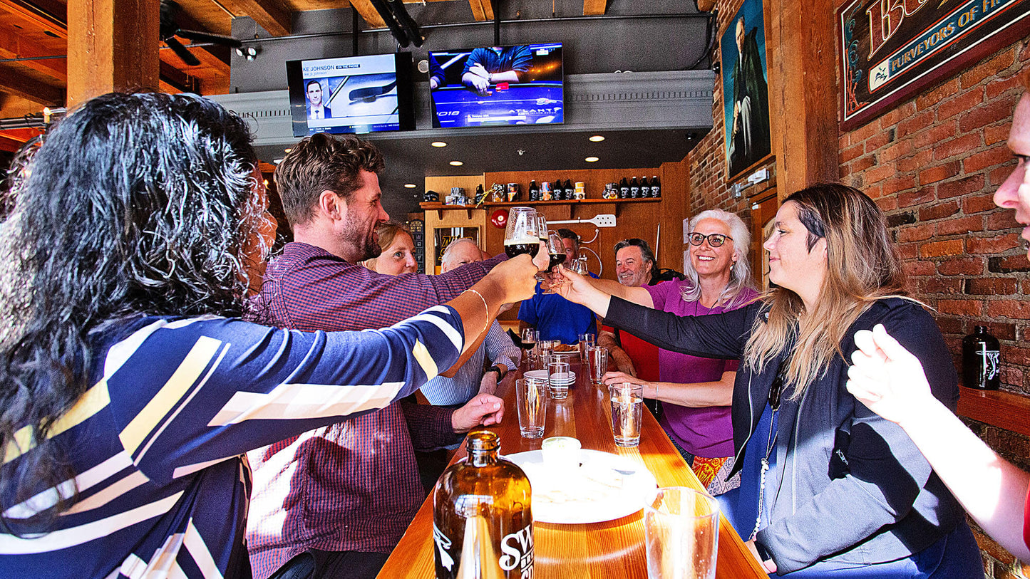 Group of people toasting with drinks in a bar setting