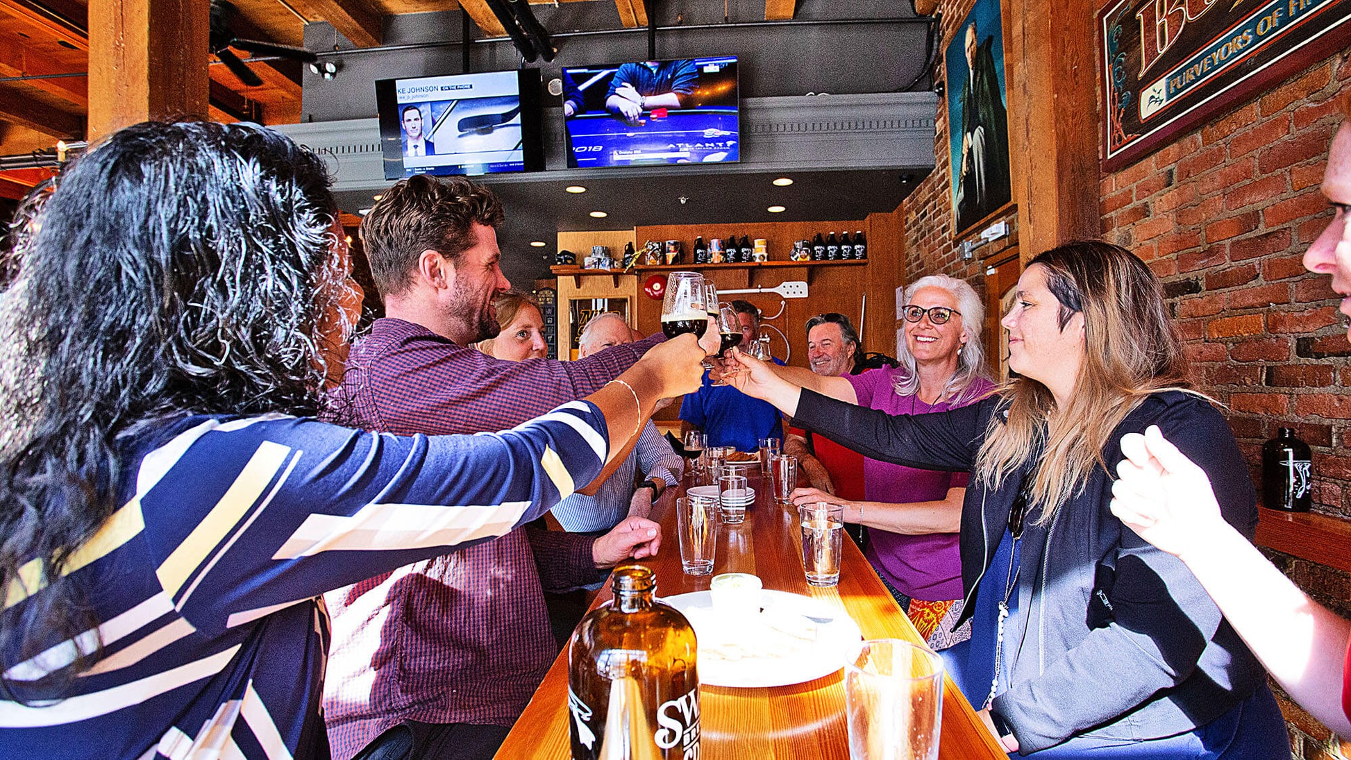 Group of people toasting with drinks in a bar setting