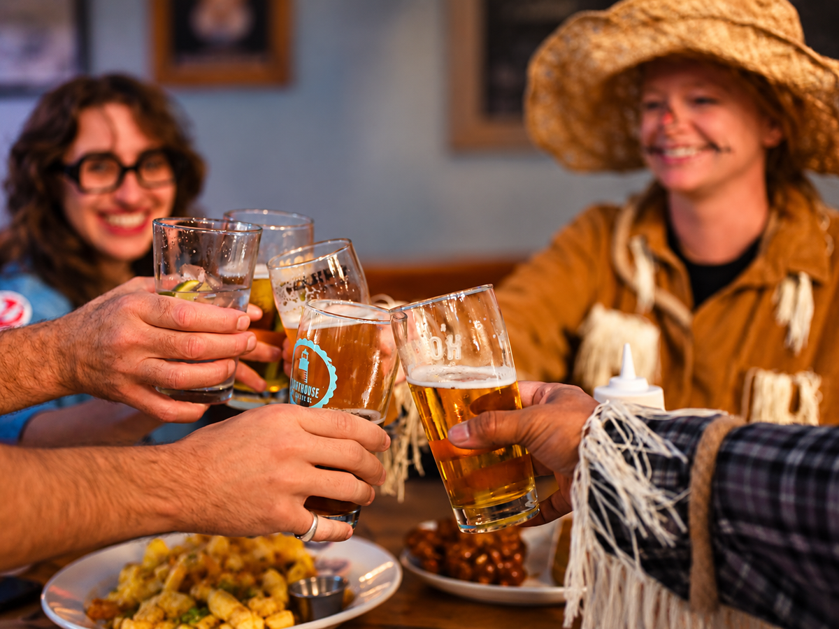 Costumed guests cheersing inside a pub having fun